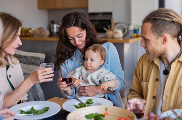 A happy multigeneration family indoors at home eating healthy lunch.