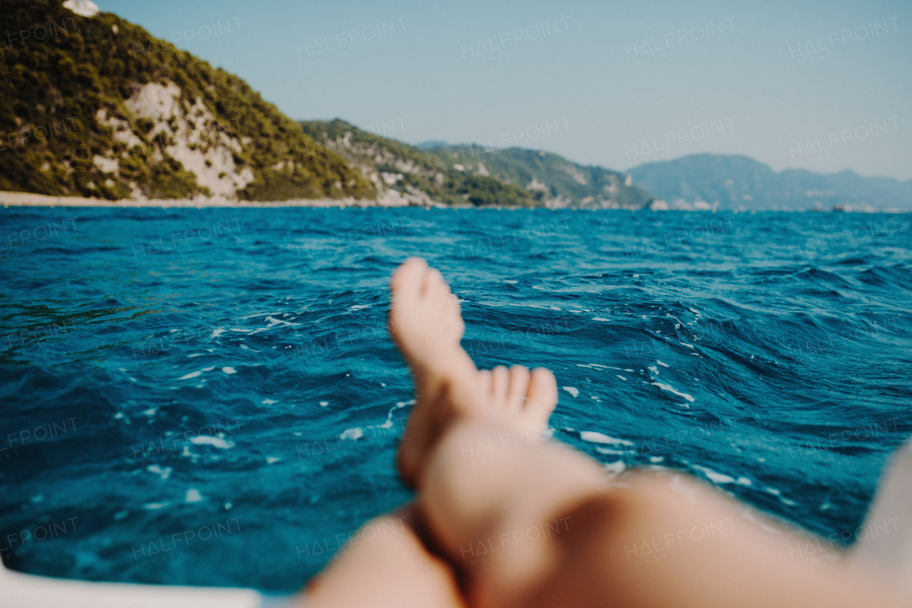 A close-up of female legs and feet on beach, summer holiday concept.