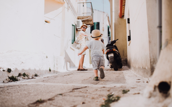 A mature father with toddler son walking in town on summer holiday.