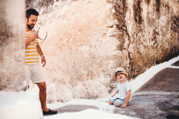 A mature father with toddler son in town on summer holiday.