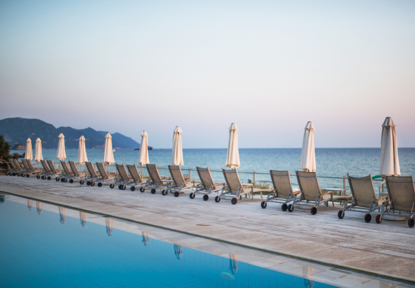 Beach chairs and umbrellas in a row on tropical beach, summer holiday concept.