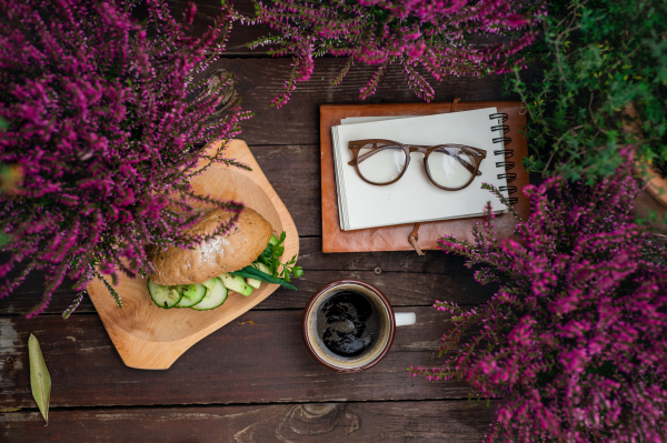 Composition of coffee, glasses and light lunch on bench outdoors on terrace.