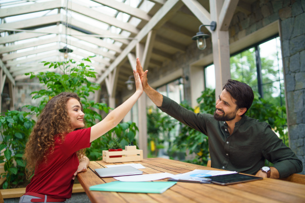 Young man and woman sitting and talking indoors in office, business meeting concept.