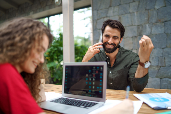 Young man and woman sitting and talking indoors in office, business meeting concept.