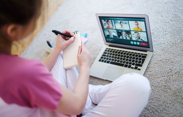 Midsection of unrecognizable young woman with laptop, online business call concept.