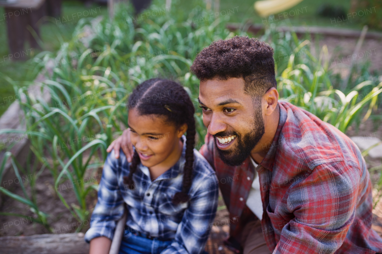 A happy young man with small sister spending time outdoors in backyard, laughing.