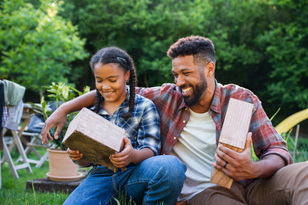 A happy young man with small sister spending time outdoors in backyard, laughing.