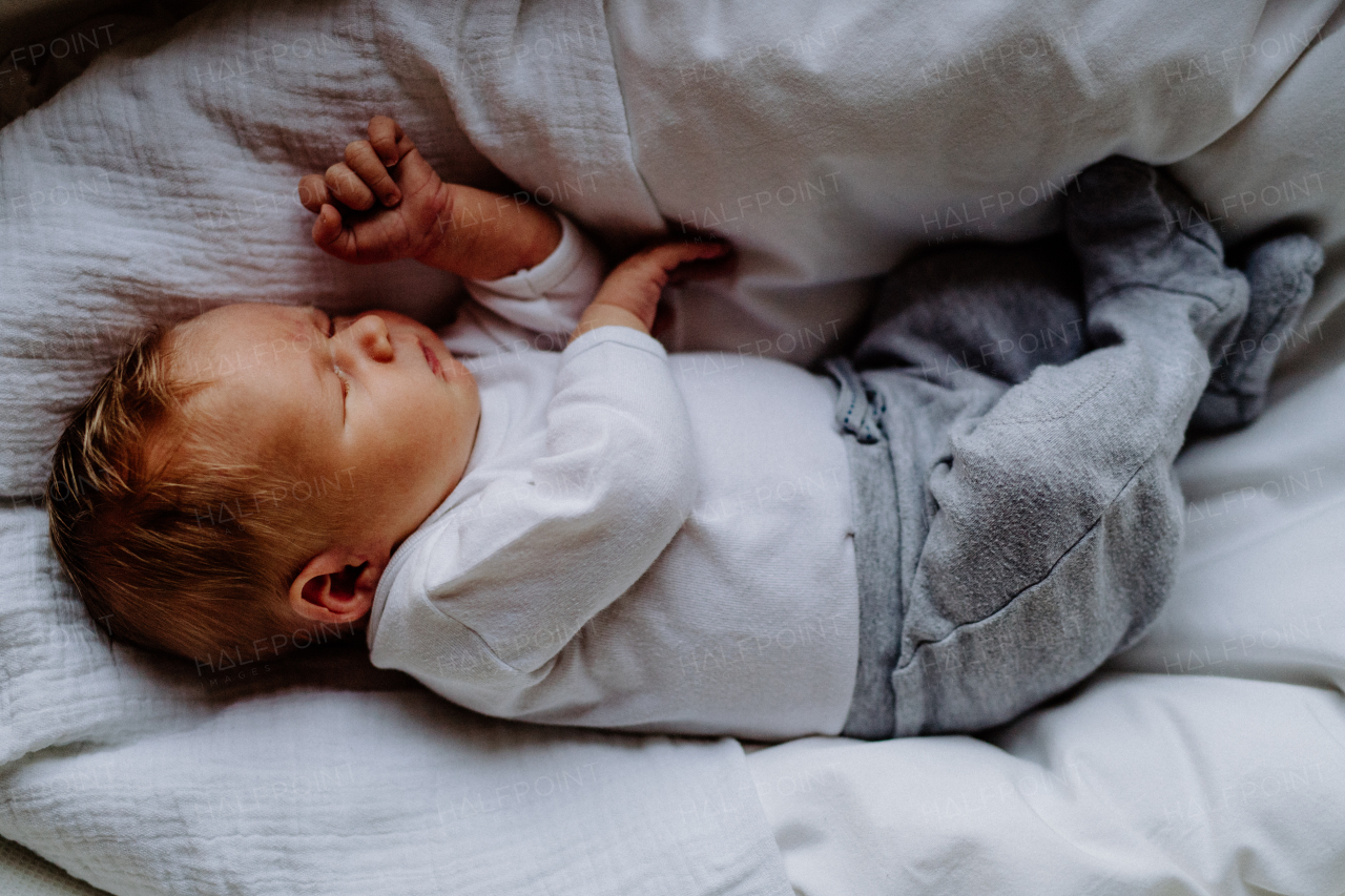 A close-up of a cute sleeping newborn baby at home, top view.