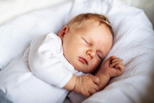 A close-up of a cute sleeping newborn baby at home.