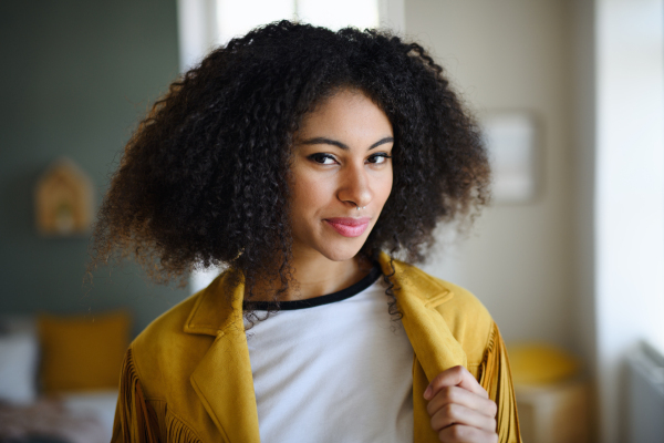 Close-up front view portrait of young woman indoors, looking at camera.