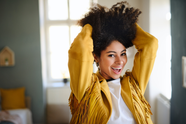 Front view portrait of laughing young woman indoors, looking at camera.