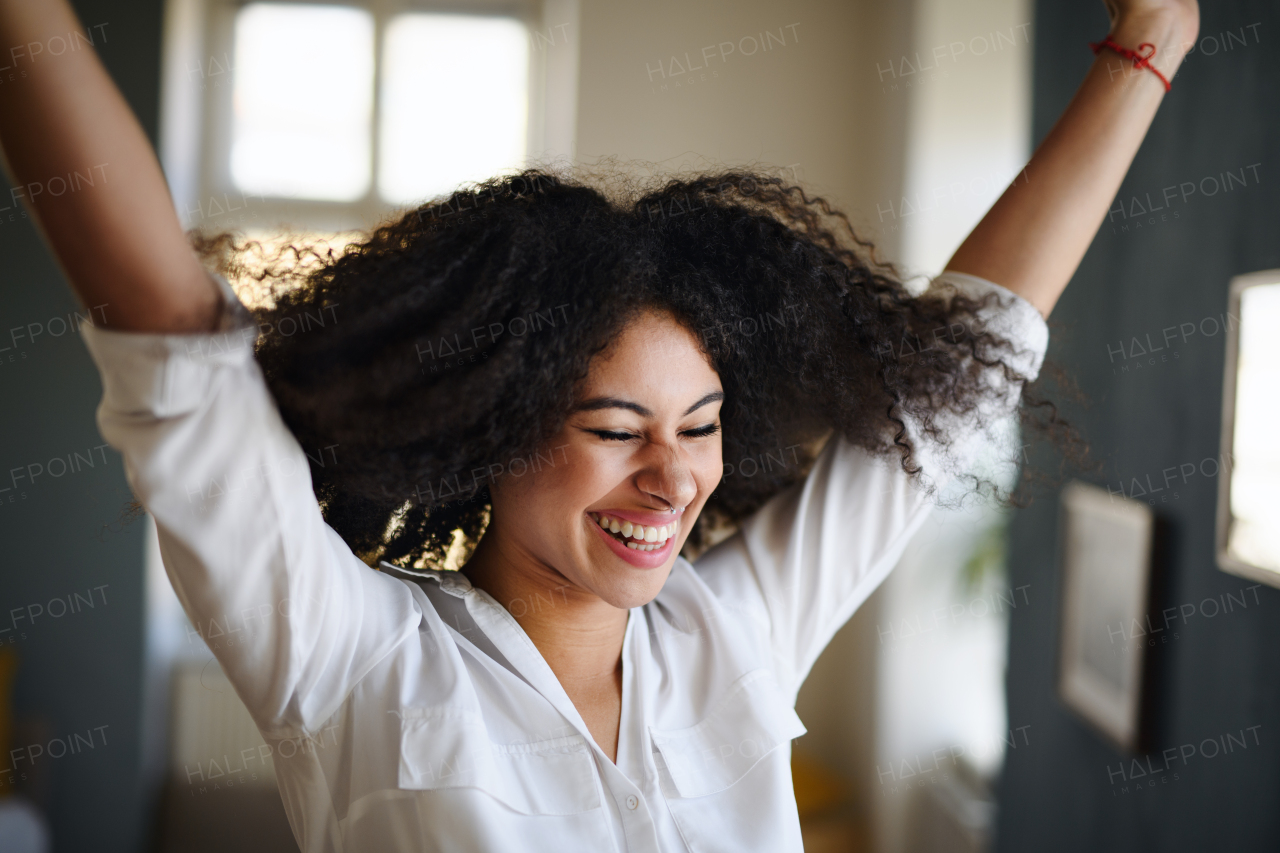 Portrait of young woman indoors, feeling happy and contented.