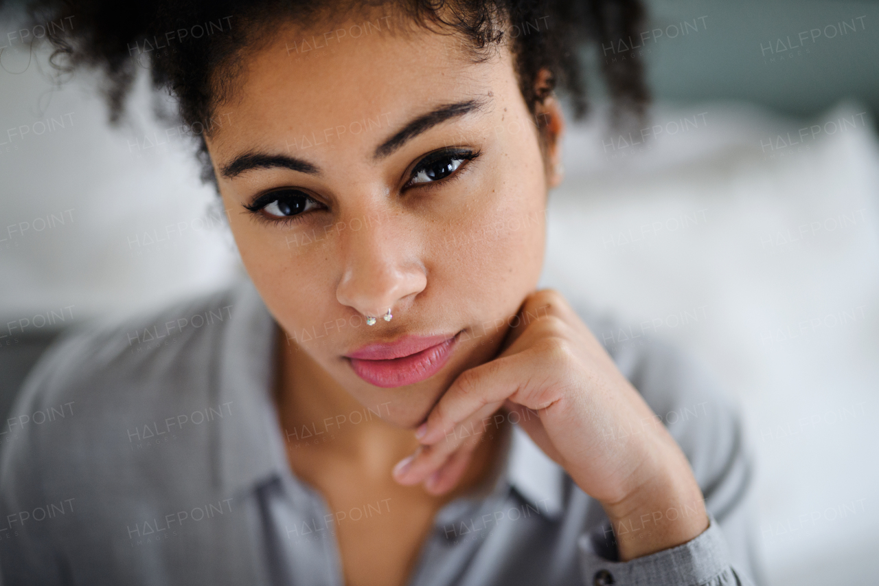 Close-up front view portrait of beautiful young woman indoors, looking at camera.