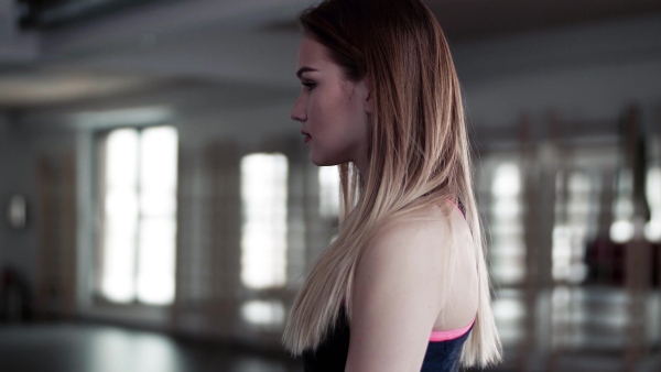 A portrait of a beautiful young girl or woman doing exercise with a kettlebell in a gym.