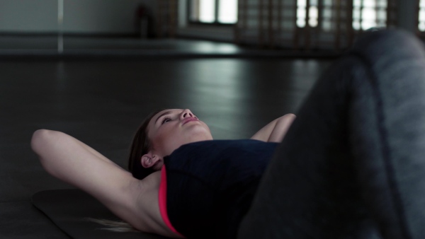 A portrait of a beautiful young girl or woman doing exercise in a gym.