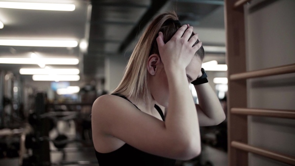 A portrait of a beautiful young girl or woman standing in a gym. Slow motion.