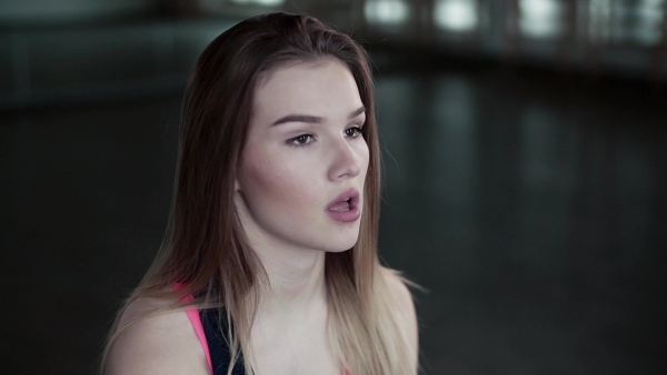 A portrait of a beautiful young girl or woman doing exercise in a gym. Slow motion.