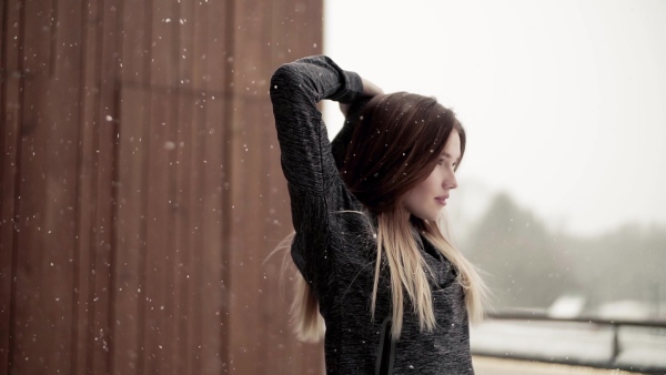 A portrait of young girl or woman doing stretching outdoors on a terrace. Slow motion.