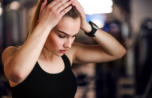 A portrait of a beautiful young girl or woman standing in a gym.