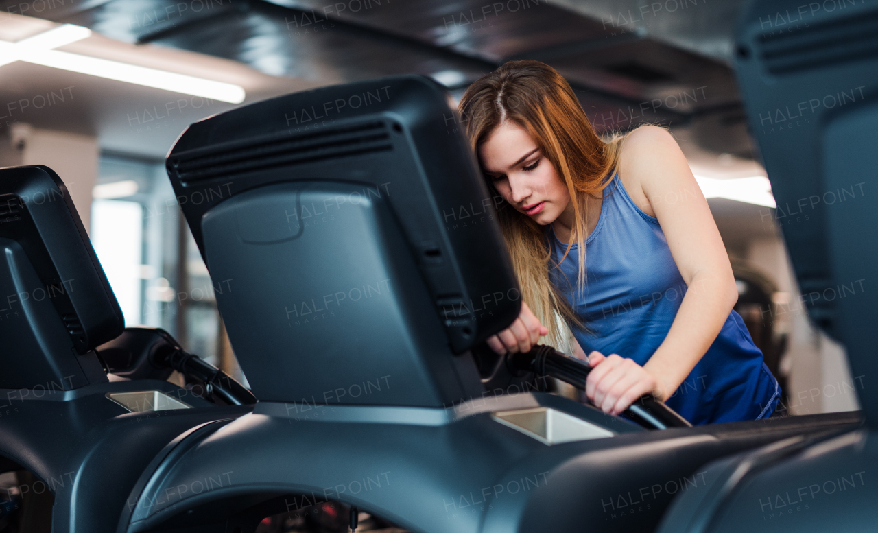 A beautiful young girl or woman doing cardio workout in a gym.