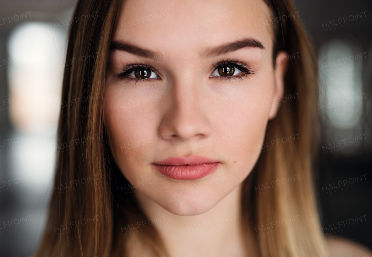 A close-up portrait of a beautiful young girl or woman standing in a gym.