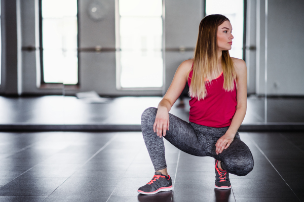 A portrait of beautiful young girl or woman in a gym. Copy space.