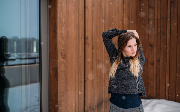 A portrait of young beautiful girl or woman doing stretching outdoors. Copy space.