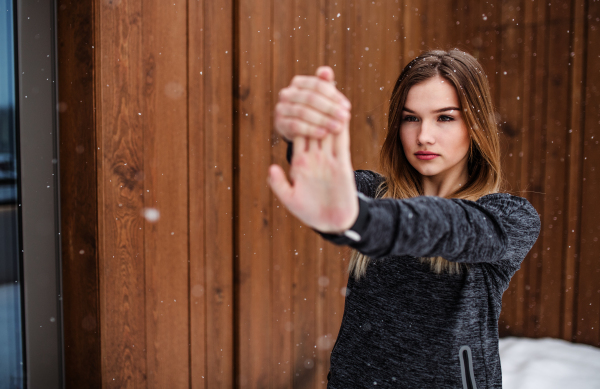 A portrait of young beautiful girl or woman doing stretching outdoors. Copy space.