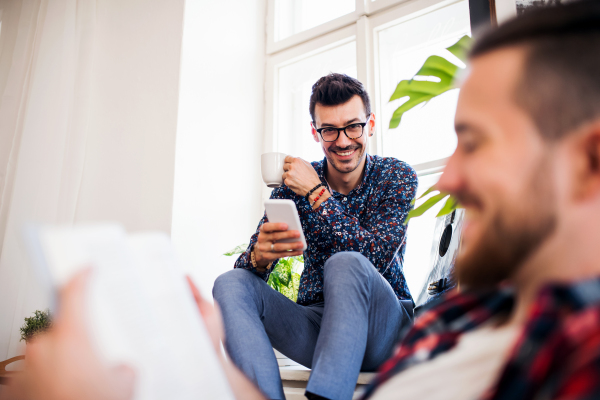 A group of young cheerful friends relaxing indoors, house sharing concept.