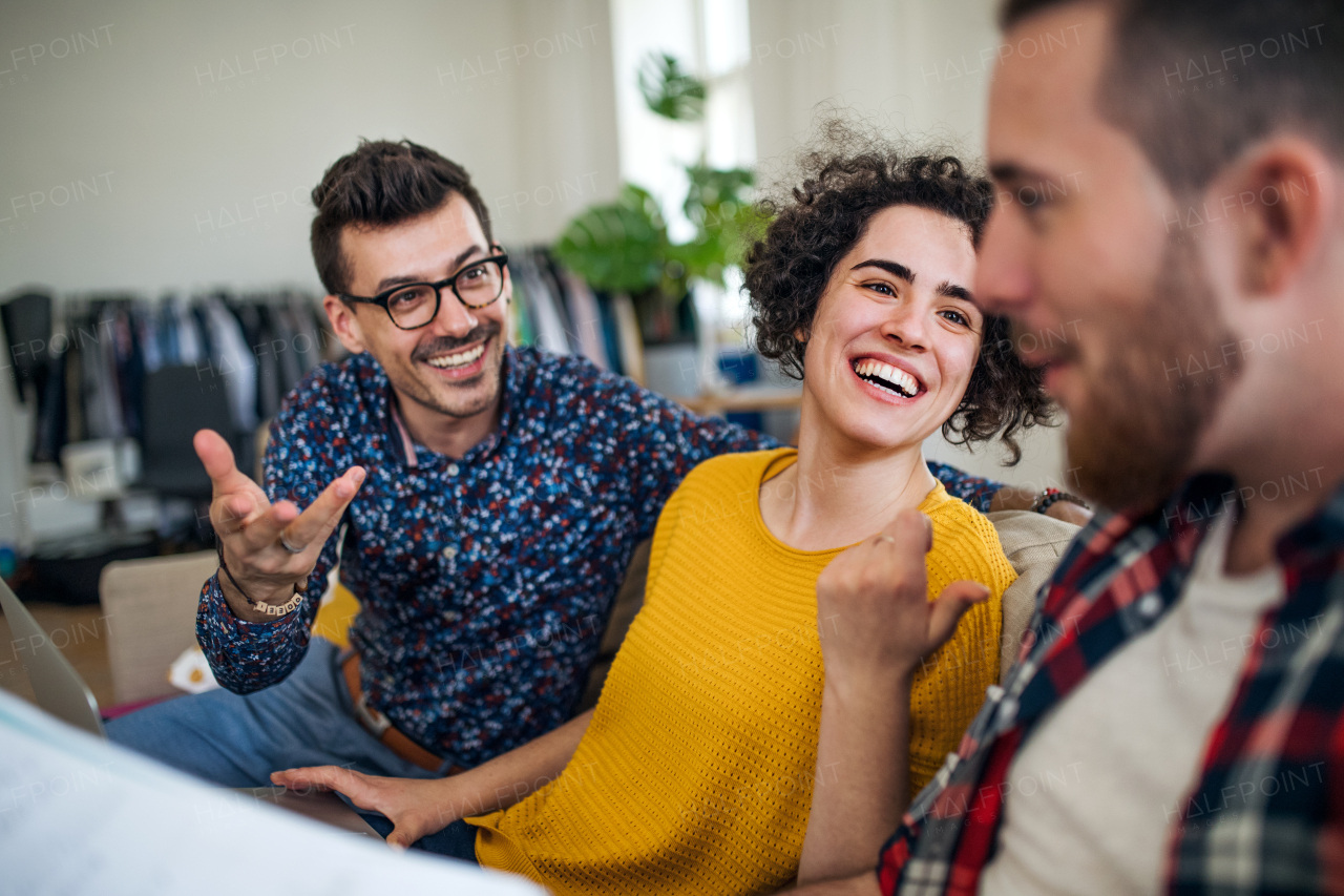 A group of young cheerful friends talking indoors at home, house sharing concept.