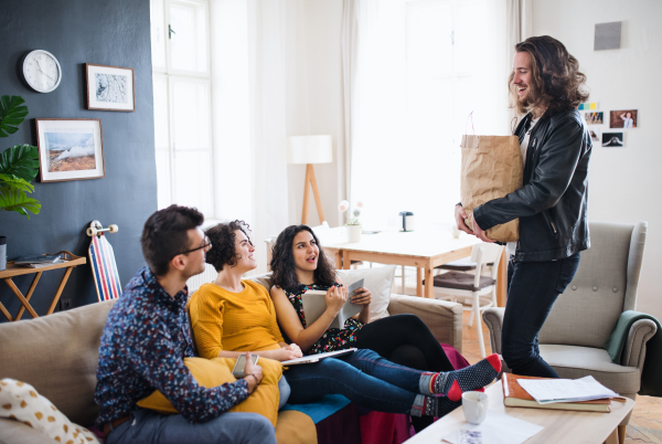 A group of young cheerful friends indoors at home, house sharing concept.