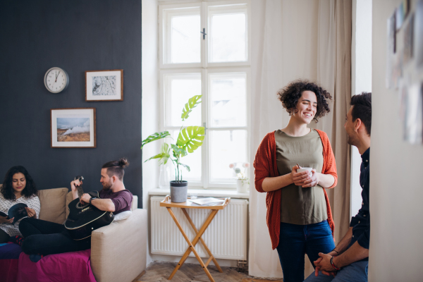 A group of young cheerful friends indoors at home, house sharing concept.