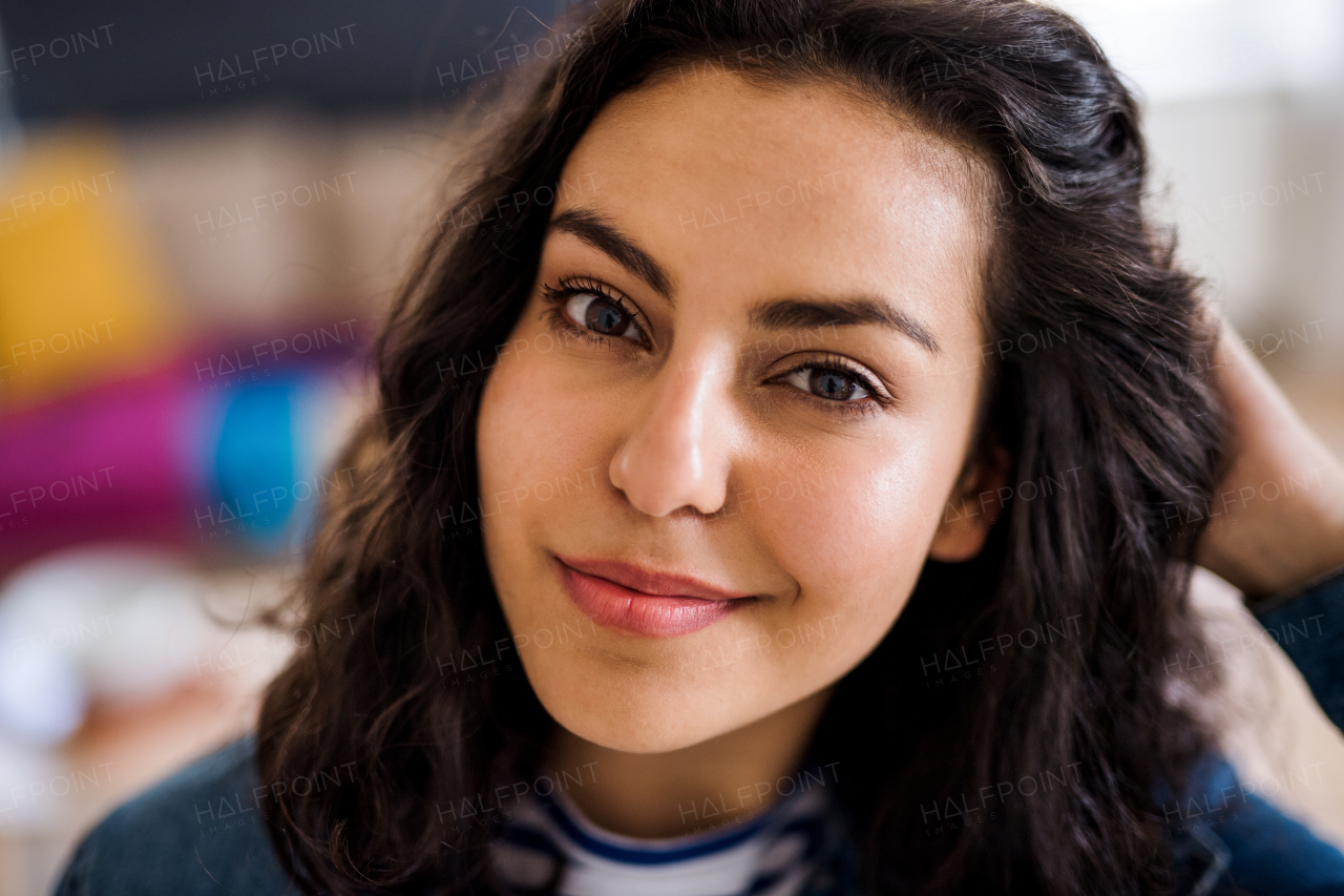 A portrait of young woman with wavy hair indoors, a close-up.