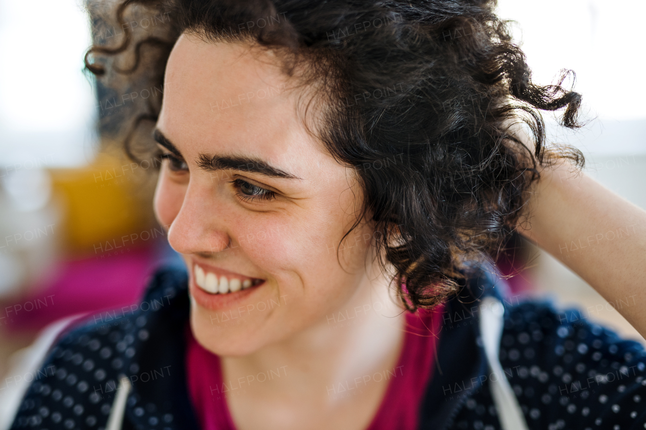 A portrait of young woman with wavy hair indoors, a close-up.