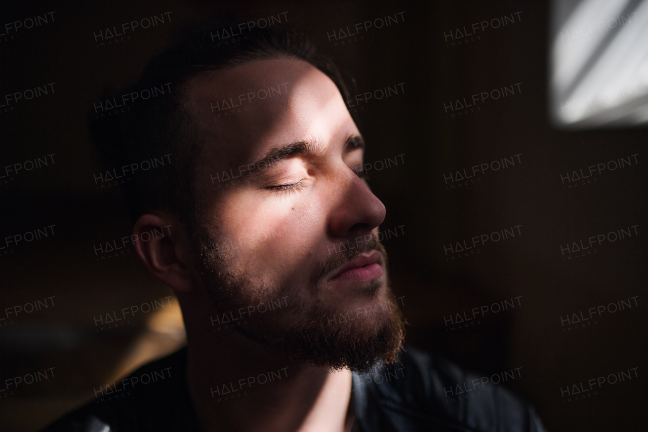 A portrait of young bearded man indoors, a close-up.