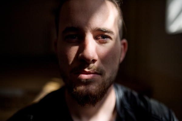 A portrait of young bearded man indoors, a close-up.