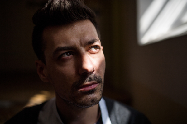 A portrait of serious young man indoors, a close-up.