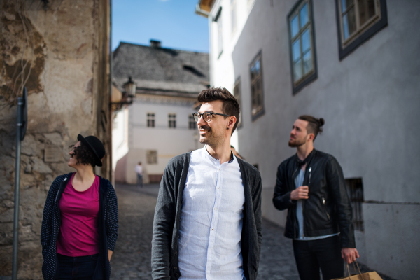 A group of young friends walking outdoor in town, talking and having fun.