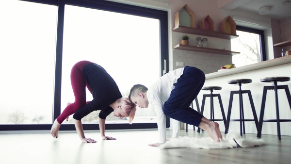 A happy young woman with small son playing on the floor, having fun.