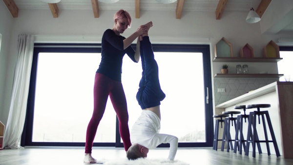 A young mother with small son doing headstand.