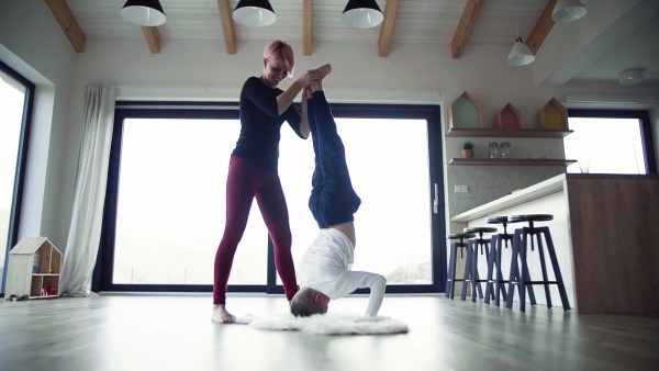 A young mother with small son doing handstand. Slow motion.