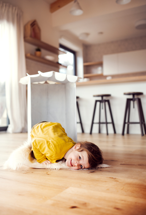 A small girl playing on the floor at home. Copy space.