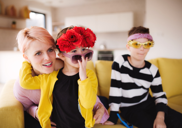 A happy young woman with two children having fun at home.