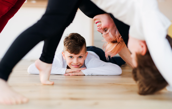 A midsection of young woman with two children playing at home, having fun.