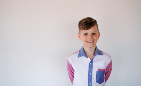 A portrait of a small boy standing against white background. Copy space.