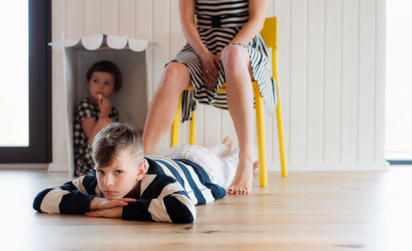 A midsection of unrecognizable young woman with two children playing at home, having fun.