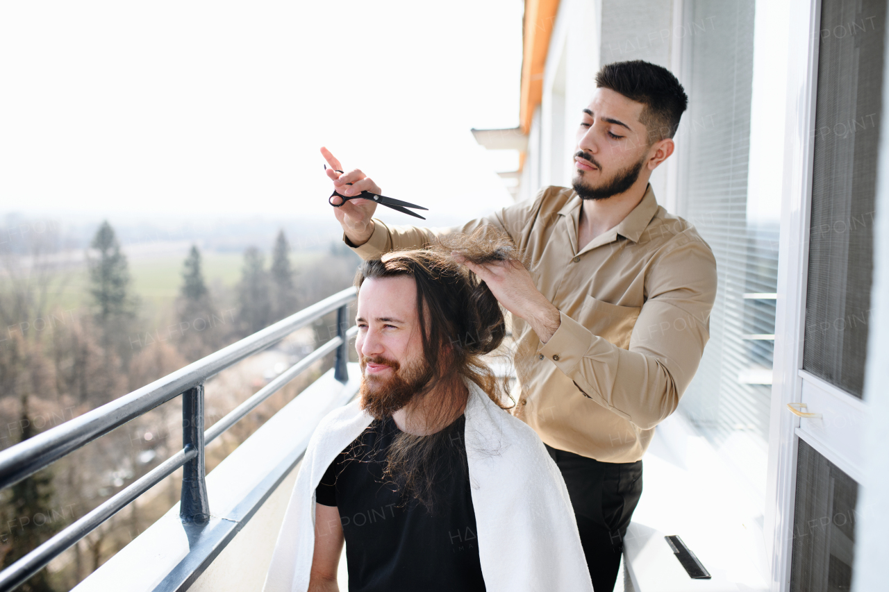 Haircut on a balcony at home, coronavirus and lockdown concept.