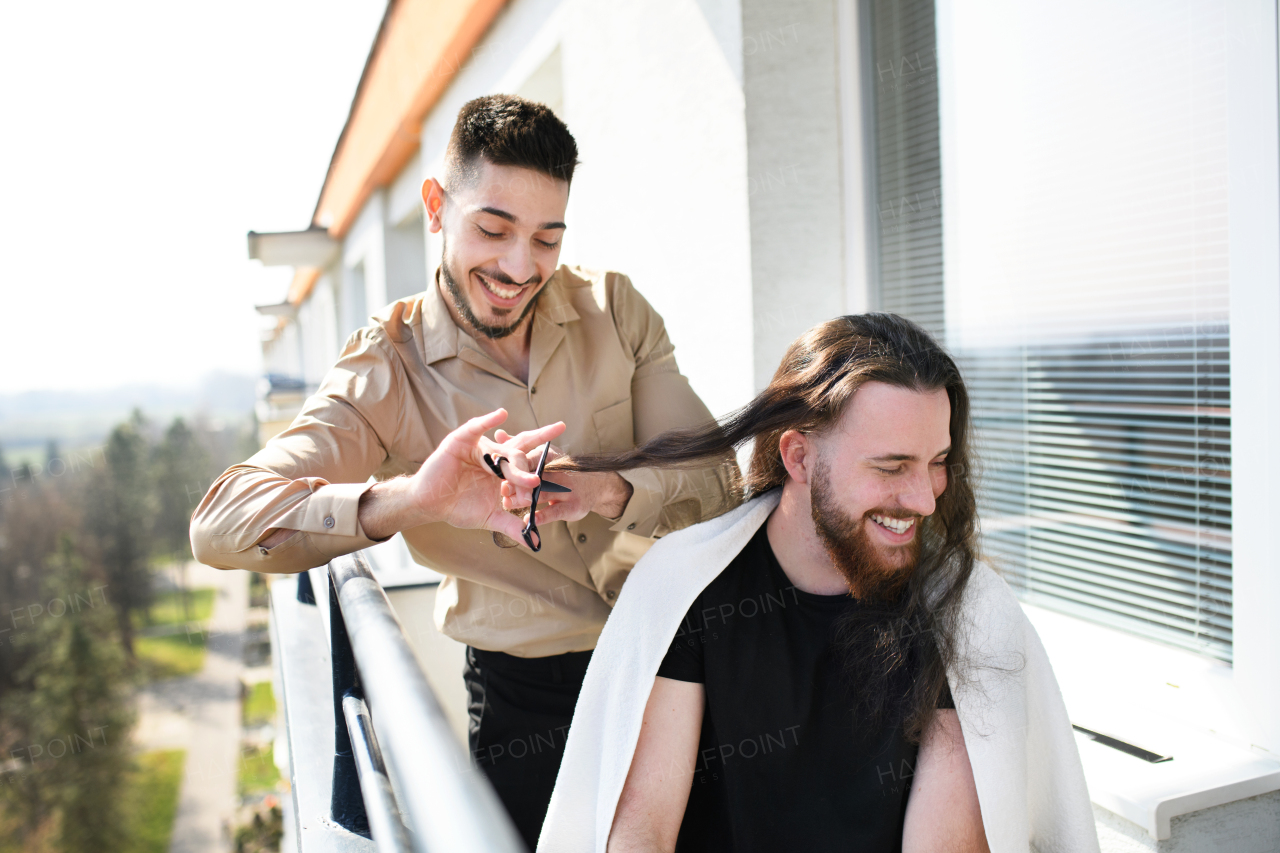 Haircut on a balcony at home, coronavirus and lockdown concept.