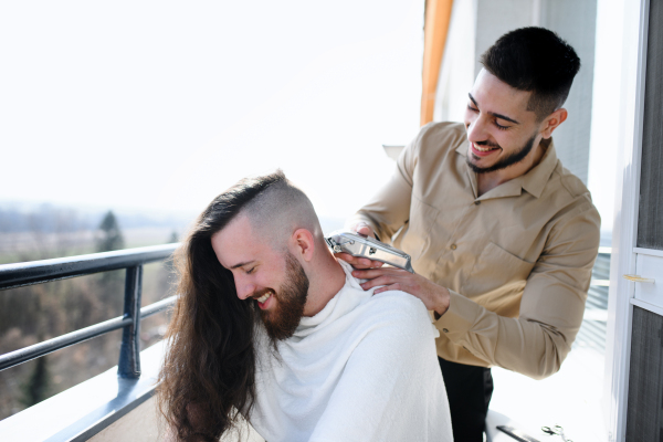 Haircut on a balcony at home, coronavirus and lockdown concept.