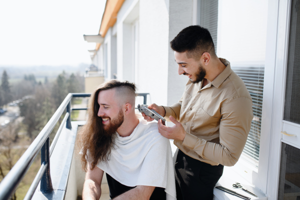 Haircut on a balcony at home, coronavirus and lockdown concept.